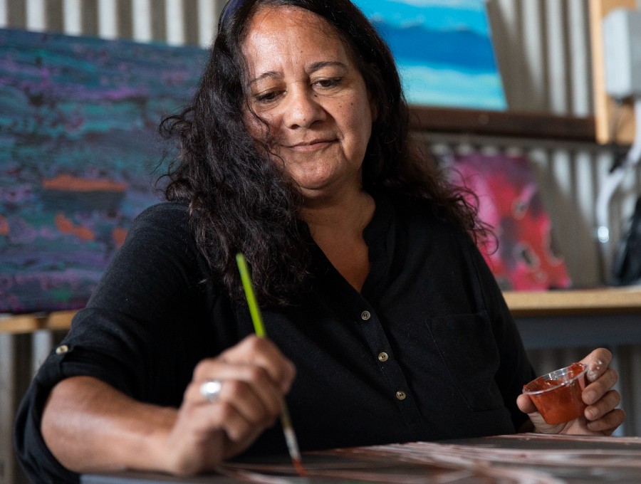 An Aboriginal woman painting.