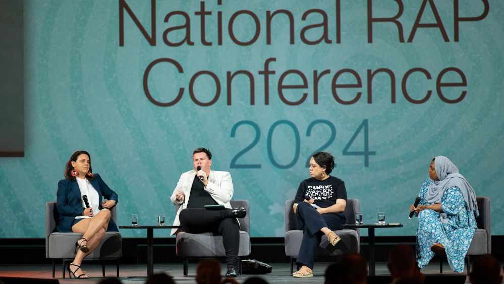Four people on a stage holding microphones at the National RAP Conference 2024.